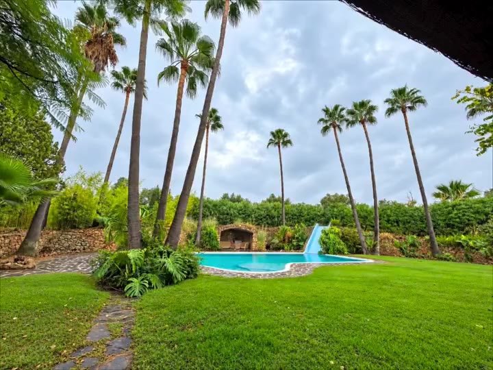 Jardín con palmeras, césped y piscina en la Costa del Sol – The Garden Boy Mijas